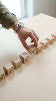 Hand placing wooden blocks with green checkmarks in row representing business process steps and quality control management.
