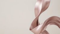 Elegant pink satin ribbon flowing gracefully with smooth curves and soft highlights on neutral background for luxury packaging and gift wrapping designs.