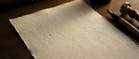 Blank handmade paper sheet with torn edges on wooden surface with vintage fountain pen, warm natural lighting for writing projects and stationery design.