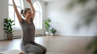 Young Caucasian woman practicing yoga meditation with raised arms in bright modern studio with plants for wellness and mindfulness training.