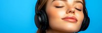 Young woman with closed eyes and serene expression wearing black wireless headphones enjoying music against bright blue background, beauty and lifestyle concept.