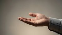 Caucasian male hand in open palm gesture against neutral background, suitable for business, charity, support, and communication concepts.