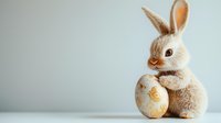 Adorable plush Easter bunny toy with decorative golden egg against light background, creating festive spring holiday atmosphere for seasonal celebrations.