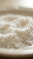 Close-up of fine white granulated salt crystals with shallow depth of field, suitable for food, culinary, seasoning, and ingredient photography.
