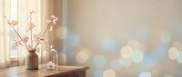 Minimalist home decor with cherry blossom branches in ceramic vase on wooden table near window with soft bokeh light background for interior design.