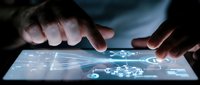 Hands interacting with futuristic holographic interface on tablet screen displaying digital network connections and data visualization technology.