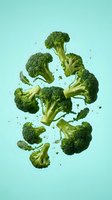 Fresh broccoli florets suspended in mid-air against turquoise background, isolated for healthy eating, nutrition, and food design projects.