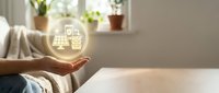 Hands holding glowing orb with smart home icons, representing connected living technology and automation solutions for residential environments.