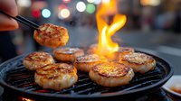 Grilled scallops on barbecue with fire flame, bokeh lights background. Fresh seafood being cooked on outdoor grill, close up view of seared shellfish.