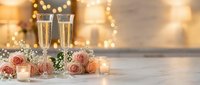 Two champagne glasses with sparkling wine surrounded by pink roses and candles against warm bokeh lights background for romantic celebration occasions.