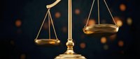 Golden scales of justice with balanced pans against dark background with warm bokeh lights for legal and law firm presentations.