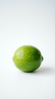 Fresh green lime with water droplets isolated on white background, suitable for food and beverage design projects.