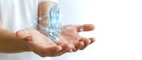 Man's hands holding transparent water bottle with splashing liquid isolated on white background for beverage, hydration, wellness and eco-friendly product design use.