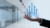 Businessman hand holding holographic city skyline with upward arrows showing urban growth and development in modern office environment.