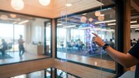 Businessman touching futuristic holographic interface display in modern office environment with glass walls and contemporary workspace design.