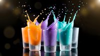 Colorful liquid splashes in glasses creating crown-like formations against dark background. Dynamic motion capture for beverage advertising and creative projects.