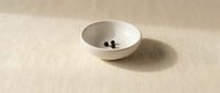Minimalist white ceramic bowl with coffee beans on neutral beige linen texture background for kitchen and dining concepts.