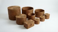 Woven rattan storage baskets set in various sizes with lids for home organization and decor on white background.