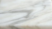 Elegant white marble surface with natural gray veining patterns creating luxurious stone texture for interior design and architectural backgrounds.