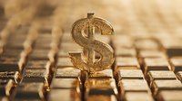 Golden dollar sign symbol standing on gold bars background with selective focus, representing wealth, financial success and investment concept.