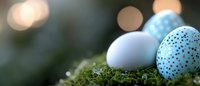 Colorful Easter eggs nestled in green moss with soft bokeh lights creating festive spring holiday atmosphere for seasonal decorations and celebrations.