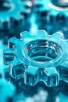 Transparent glass gear wheel in blue tones with mechanical components in background, representing industrial technology and engineering innovation.
