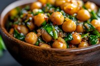 Spiced chickpeas with fresh herbs in wooden bowl, close up view. Healthy vegan protein meal with garbanzo beans and parsley in rustic setting.