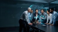 Diverse business team collaborating around holographic data visualization in modern conference room with futuristic technology interface.