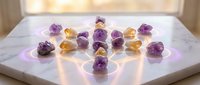 Raw amethyst and citrine crystals arranged on white marble surface with warm lighting for healing meditation and spiritual wellness practices.