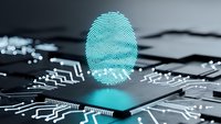 Glowing cyan fingerprint hologram floating above computer processor chip with circuit board patterns for cybersecurity and digital identity technology concepts.