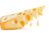 Fresh yellow Swiss cheese wedge with characteristic holes and melting drops on white background, isolated food photography for culinary designs.