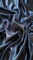 Luxurious dark gray silk fabric with elegant folds and waves creating smooth flowing texture. Abstract background for fashion and luxury design projects.