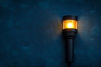 Glowing outdoor wall lamp illuminating dark blue textured wall at night, creating atmospheric lighting and dramatic shadows for exterior design.