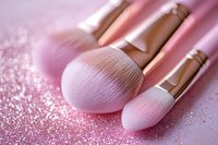 Pink makeup brushes on glittery rose gold background with soft focus effect, professional cosmetic tools for beauty and fashion industry applications.