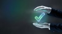 Hands in white gloves holding glowing neon checkmark symbol between palms against dark background. Represents approval, success, quality assurance, and verification concepts for business presentations.