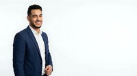 Young male professional of Latin American descent wearing navy blazer and white shirt, smiling confidently against white background. Suitable for corporate, business, and professional website design.