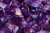 Raw amethyst crystal chunks in deep purple and lavender hues create abstract geometric pattern, illuminated from behind on light background, macro photography view.