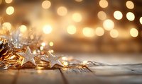 Silver star decorations with warm glowing fairy lights creating magical bokeh effect on rustic wooden surface, festive holiday atmosphere for Christmas and winter season.