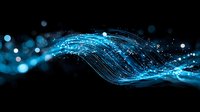 Glowing blue wave of light streams and particles flowing on dark background with bokeh effect creates futuristic technology concept.