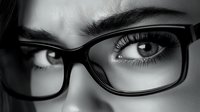 Close up monochrome portrait showing expressive eyes behind stylish black-framed glasses, capturing intense gaze and natural eyelashes in dramatic lighting.