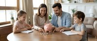 Happy Caucasian family with two children counting coins from piggy bank at home table, teaching kids financial literacy and saving money habits.