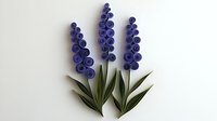 Purple paper quilled flowers with green leaves arranged on white background, handcrafted decorative botanical art piece showing delicate spiral technique.
