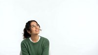 Young woman with dark wavy hair and olive skin tone wearing green casual shirt, looking upward thoughtfully against white background, isolated for design use.