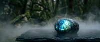 Mystical labradorite gemstone with blue flash resting on dark stone surface surrounded by ethereal mist and lush green foliage creating magical atmosphere.