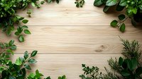 Fresh green leaves and plants creating natural border frame on light wooden background, copy space for text in center. Perfect for organic design layouts.