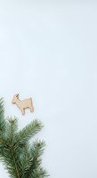 Wooden goat ornament isolated on white background with evergreen branches, ready for holiday design, crafts, and seasonal decoration projects.