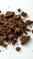 Crumbled whole wheat bread and scattered crumbs isolated on white background, suitable for food photography, baking content, and culinary design projects.