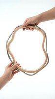Hands holding wooden embroidery hoop on white background isolated for crafting and needlework projects.