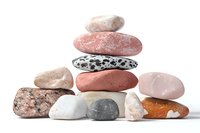 Balanced stack of natural stones and minerals in soft pink, white, and gray tones on white background, isolated composition for wellness and spa designs.