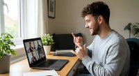 Young Caucasian man with curly hair in casual sweater having video call on laptop at home office desk, remote work communication and online meeting concept.